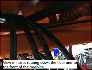 View of hoses routing down the floor and to the front of the machine during the scraper blade install.